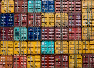 Yellow, red, orange and blue shipping containers stacked on top and beside each other