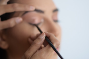 Woman having make-up applied to her face